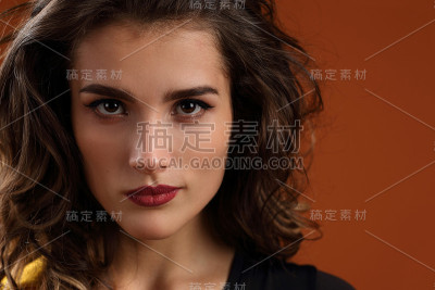 一个棕色背景上的美丽女孩的肖像