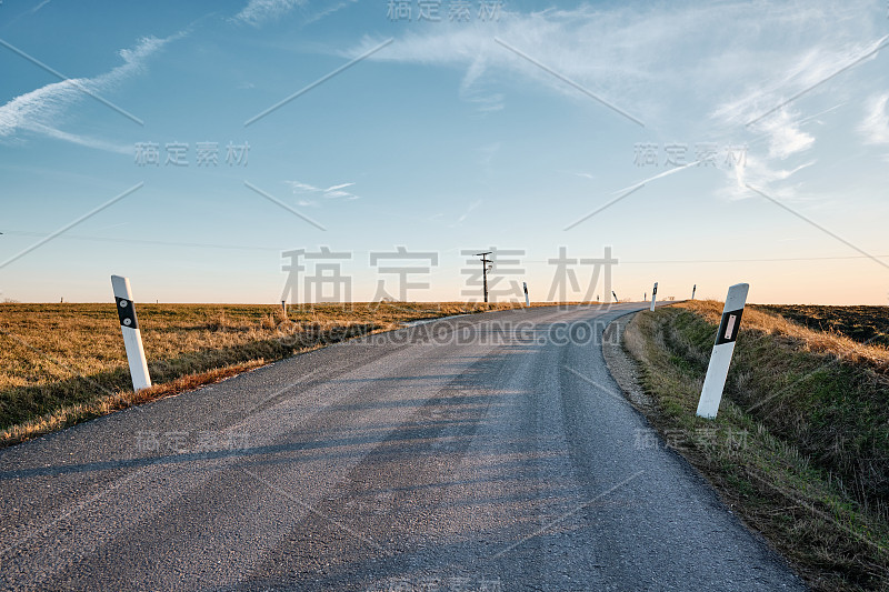 长长的弯曲的乡村道路映衬着蓝天