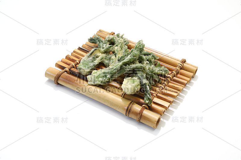 在竹筏形的餐具上，有一种叫“天妇罗”的野生蔬菜