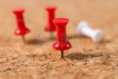 软木布告栏上的红白两色图钉。