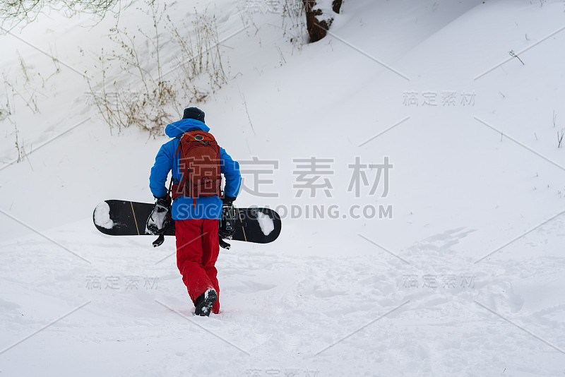 背着背包的滑雪者爬上斜坡