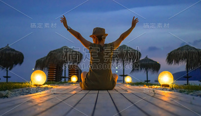 一个快乐的女人在通往大海的木制小路上