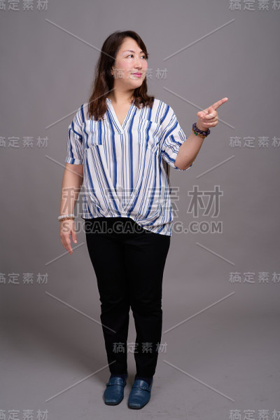 工作室拍摄的成熟美丽的亚洲女商人在灰色的背景