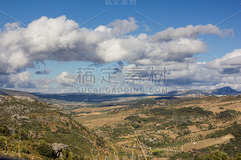 山景上的蓝色多云的天空背景。风景如画的群山在阳光下闪闪发光。令人屏息的自然影像