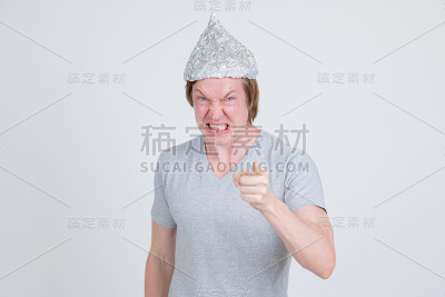 一名愤怒的年轻人戴着锡纸帽，将阴谋论的概念指向摄像机