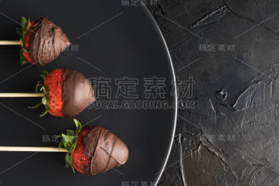 草莓和巧克力，在一个黑色盘子上俯视图