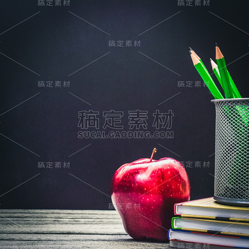 回归学校和教育理念。教室有苹果，书和铅笔在黑板上的背景。学校边界与副本空间