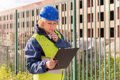 一位女建筑工在建筑工地检查建筑物