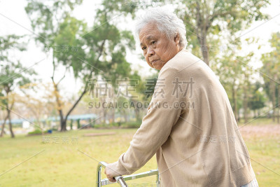 亚洲老年妇女或老年妇女病人步行与步行者在公园与复制空间，健康强医疗理念
