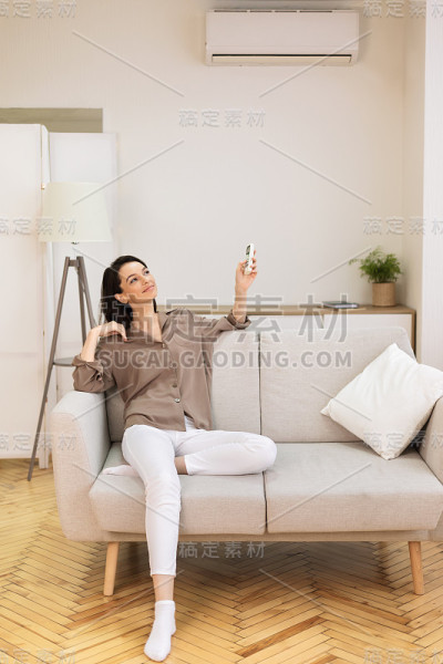 在她的智能房子里打开空调的女孩