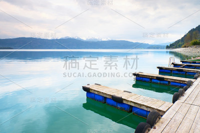 蓝色阿尔卑斯山湖与码头鼹鼠为旅行船。