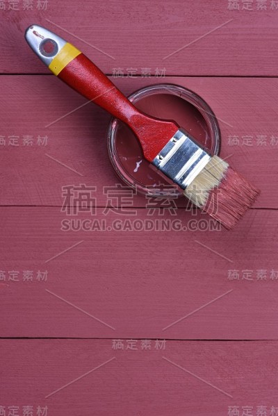粉色油漆罐与刷子在木制背景