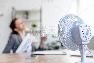 有选择地关注坐在电扇旁边受热的女商人