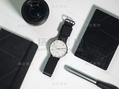 平铺办公用品，相机镜头，手表外置硬盘