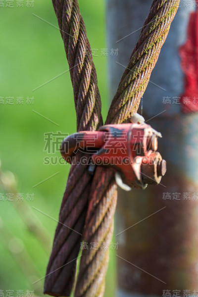生锈的旧钢缆，以前的屏障上覆盖着苔藓