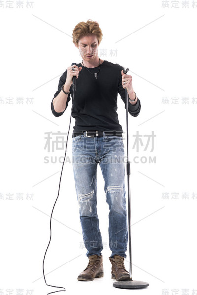 年轻帅气的摇滚歌手从支架上拿出麦克风。