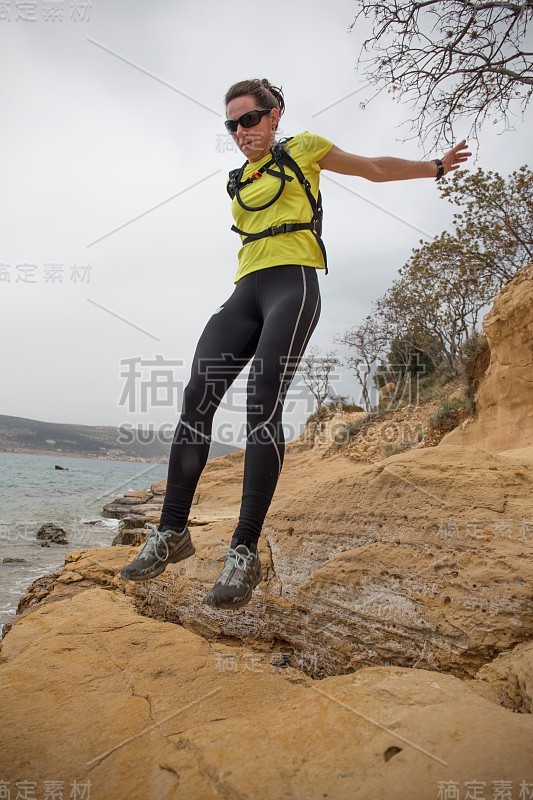 一个女人拿着运动器材在海岸线上跳。克罗地亚达尔马提亚地区，Starigrad的Paklenica。