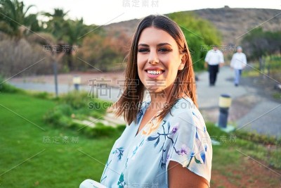 年轻美丽和优雅的女人与婚礼的客人服装微笑快乐和愉快