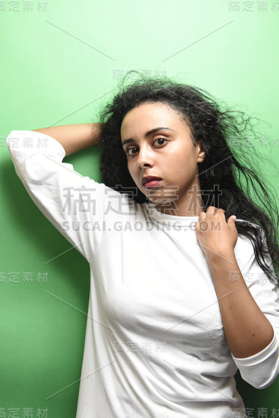 有着一头黑发的中东年轻女子。室内照片的奇妙女性模特在绿色的背景。