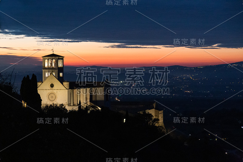 阿西西的圣弗朗西斯教皇教堂的夜景，以城市的灯光为背景