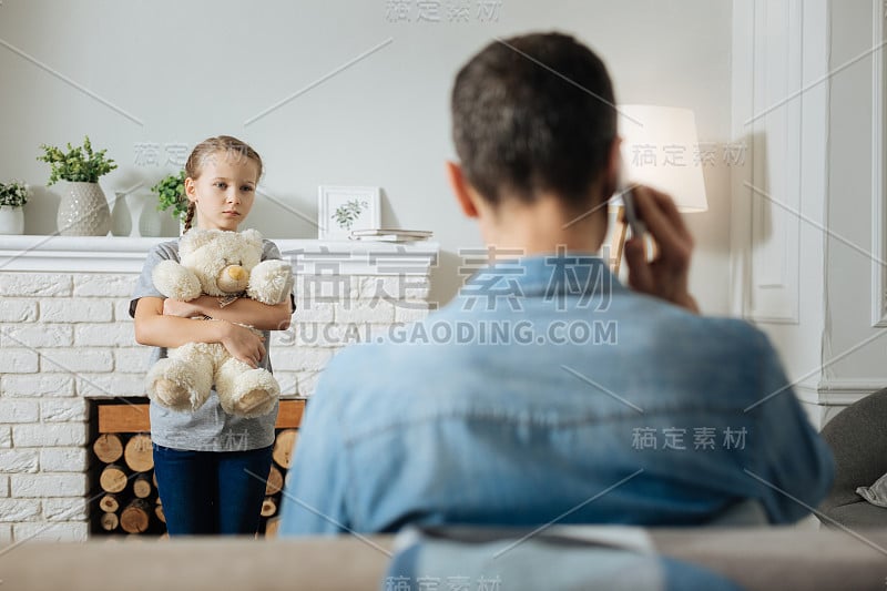 可怜的孩子看着她父亲打电话