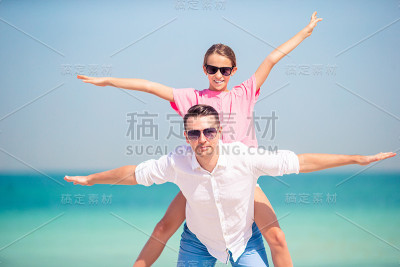 小女孩和快乐的爸爸在海滩度假玩得很开心
