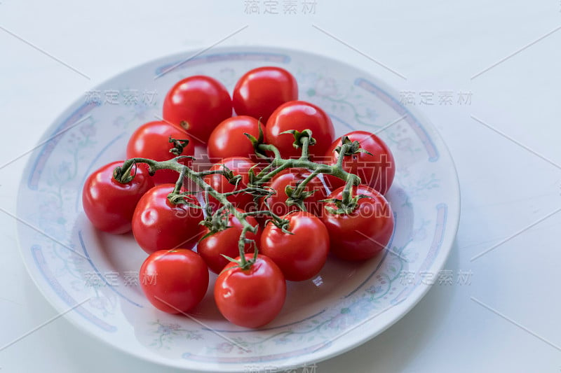 一些小可爱的西红柿在盘子里的高角度拍摄。特写照片。