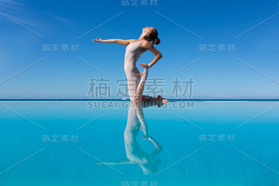 在泳池边做瑜伽的女人。