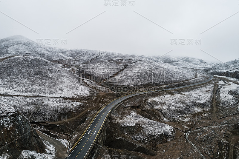 蜿蜒穿过被雪山环绕的山谷的乡村道路