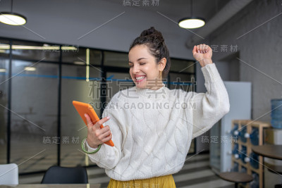 一名年轻女子举起手臂看着平板电脑