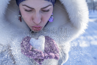 女人吹心形雪球的特写