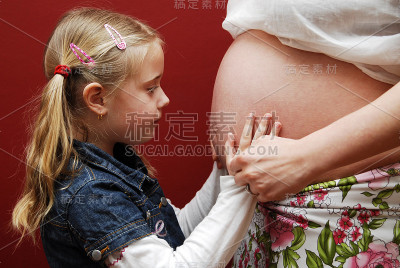 女孩抱着妈妈的肚子