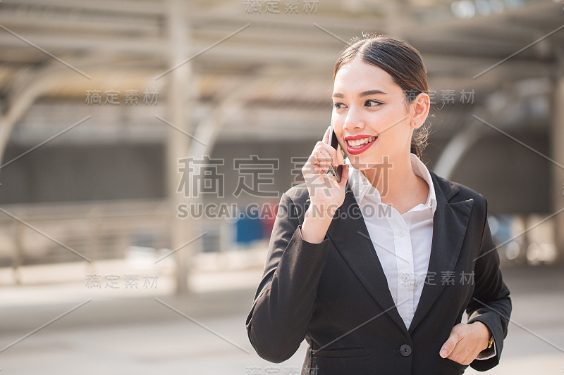 现代微笑美丽的商务女性使用智能手机与拷贝空间