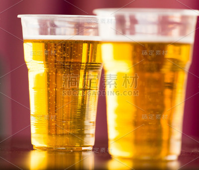 桌上放着塑料杯里的新鲜啤酒