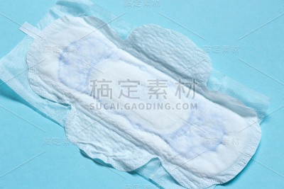 打开蓝色背景的白色女性卫生垫。宏,关闭。