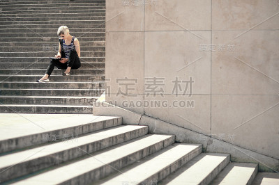年轻的金发女人在用平板电脑。