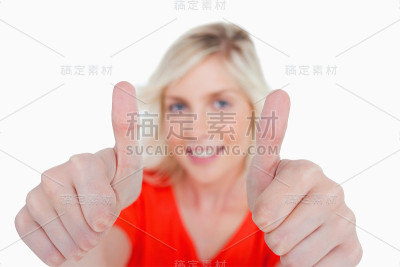 一个年轻的金发女人竖起大拇指