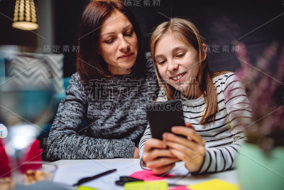 母女俩在用智能手机