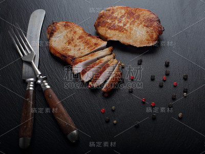 用刀叉在石板上烤牛排。特写镜头