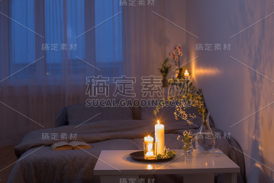 卧室里的夜晚装饰着鲜花和燃烧的蜡烛
