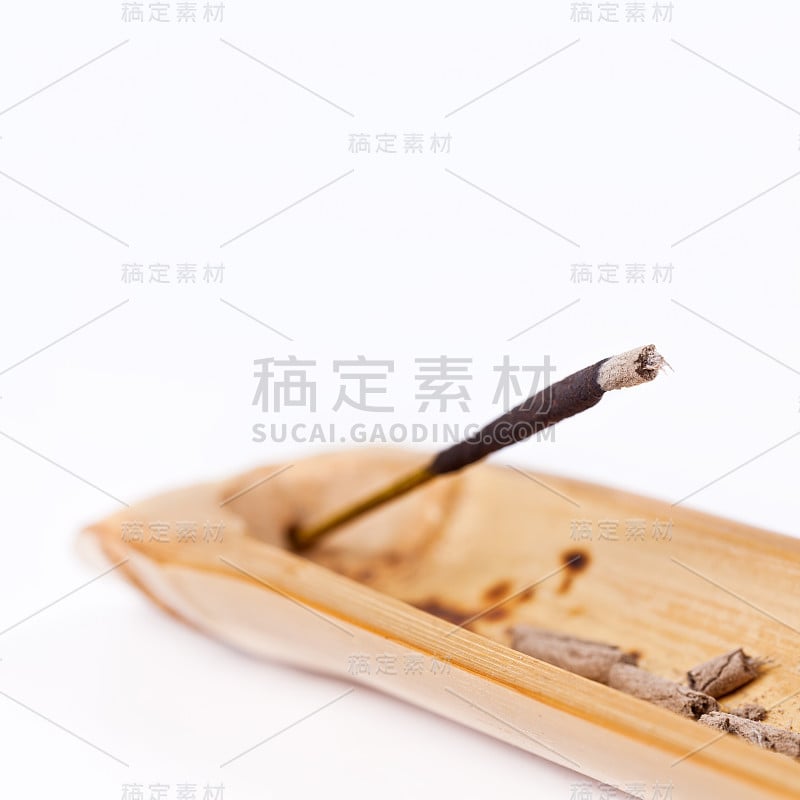 香的特写燃烧在白色的木制烛台上