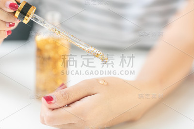 特写:她手上有橙黄色的液体凝胶或血清。