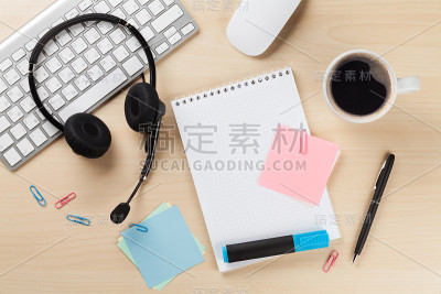 带耳机的办公桌和办公用品。呼叫中心