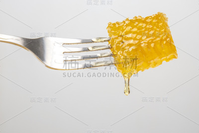 新鲜的蜂蜜滴在叉子上。维生素营养和蜂产品。