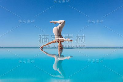 在泳池边做瑜伽的女人。