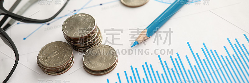 一堆银币躺在财务图表文件上