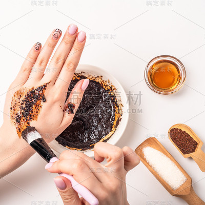 一名妇女用刷子在手上擦咖啡粉