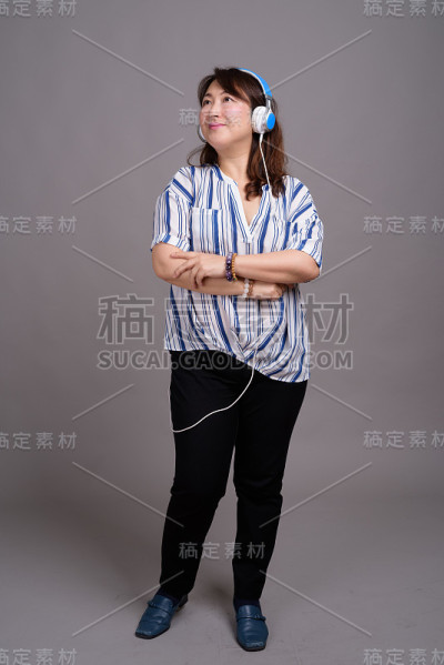 工作室拍摄的成熟美丽的亚洲女商人在灰色的背景