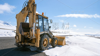黄色的挖掘机在冰雪覆盖的冰岛公路上