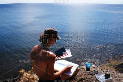 年轻的艺术家正在画一幅美丽的海景画